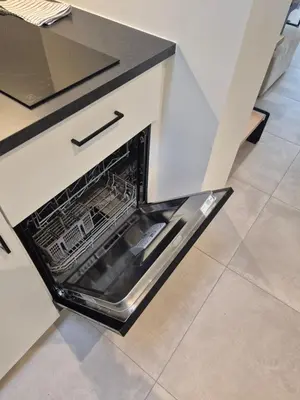 an open dishwasher in a kitchen with a counter at Huis ALNA 10 in Mechelen