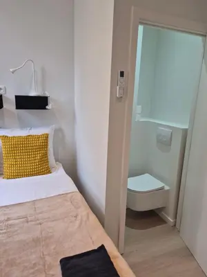 a small bathroom with a bed and a toilet at Huis ALNA 10 in Mechelen