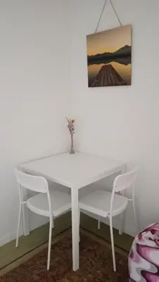 a white dining room table with two chairs and a painting at Lieria in Lier