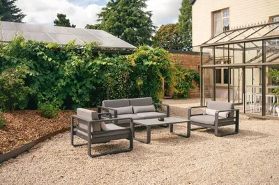 a patio with chairs and a table and a greenhouse at Villa Paulette