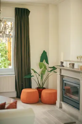 a living room with orange ottomans and a fireplace at Villa Paulette