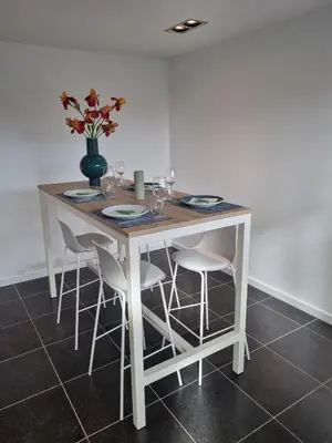 a white table with chairs and a vase with flowers at Le Jardin in Wommelgem