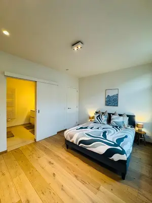 a bedroom with a bed with a blue and white comforter at The 9th Street Residence in Brussels