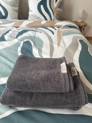 a pile of towels sitting on top of a bed at The 9th Street Residence in Brussels
