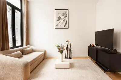 a living room with a couch and a tv at Stylish 1BR Apartment near Zuid in Antwerp