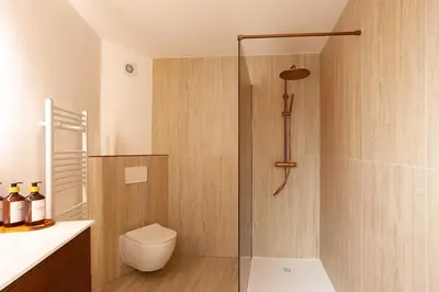 a bathroom with a glass shower with a toilet at Stylish 1BR Apartment near Zuid in Antwerp