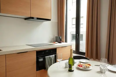 a kitchen with a table with a plate of food and wine glasses at Stylish 1BR Apartment near Zuid in Antwerp