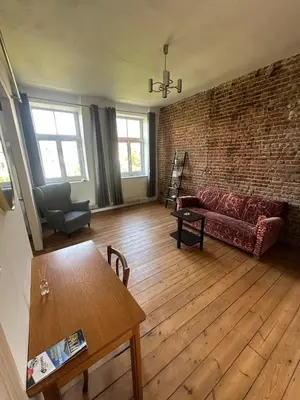a living room with a couch and a brick wall at Big cosy Family Duplex near Grande Place in Brussels