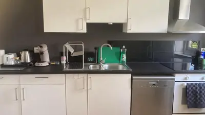 a kitchen with white cabinets and a sink at Big cosy Family Duplex near Grande Place in Brussels