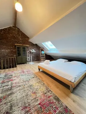 a bedroom with a bed and a brick wall at Big cosy Family Duplex near Grande Place in Brussels