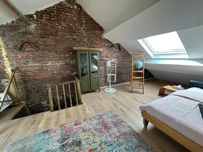 a bedroom with a brick wall and a green door at Big cosy Family Duplex near Grande Place in Brussels