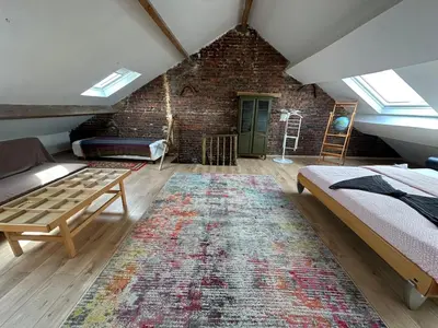 a attic room with a bed and a rug at Big cosy Family Duplex near Grande Place in Brussels