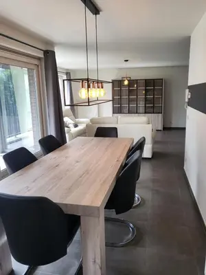 a dining room with a wooden table and chairs at Ruim appartement met terras in Ghent