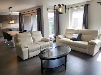a living room with two couches and a coffee table at Ruim appartement met terras in Ghent