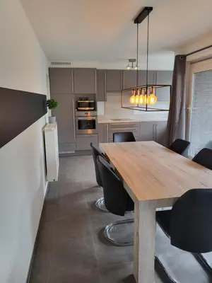 a kitchen with a wooden table and black chairs at Ruim appartement met terras in Ghent