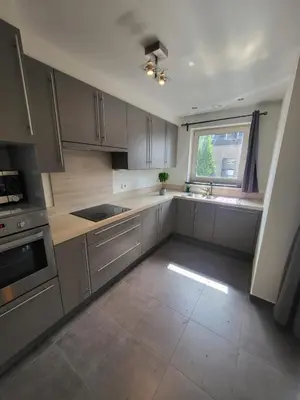 a kitchen with stainless steel appliances and a window at Ruim appartement met terras in Ghent
