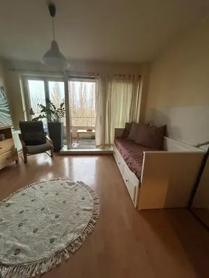 a living room with a bed and a large window at Modern Studio with Terrace Woluwe-Saint-Lambert in Brussels