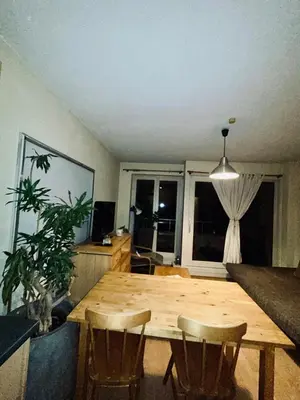 a living room with a wooden table and chairs at Modern Studio with Terrace Woluwe-Saint-Lambert in Brussels