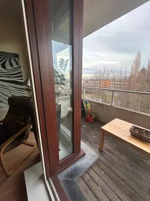 a sliding glass door on a balcony with a table at Modern Studio with Terrace Woluwe-Saint-Lambert in Brussels