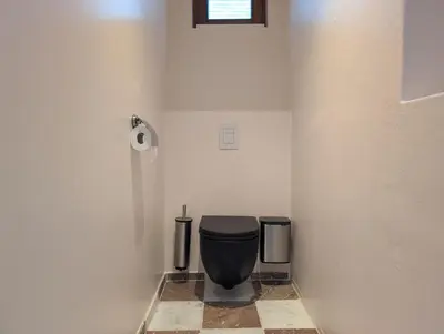 a bathroom with a black toilet and two trash cans at Geldmunt 37 in Ghent