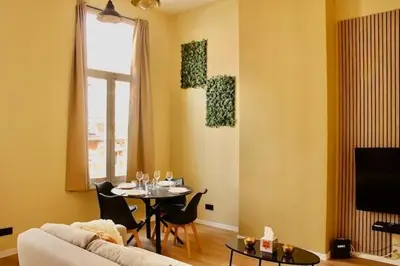 a living room with a table and a couch at Nice one-bedroom apartment in Brussels