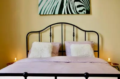 a bed with two pillows and a painting on the wall at Nice one-bedroom apartment in Brussels