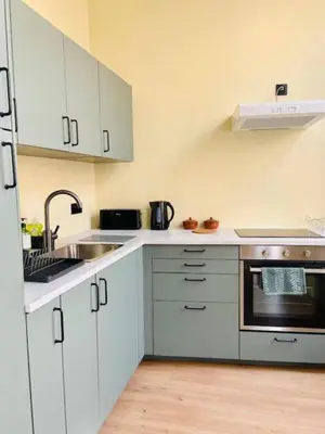 a kitchen with white cabinets and a sink at Nice one-bedroom apartment in Brussels