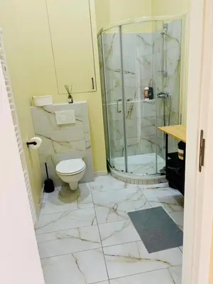 a bathroom with a toilet and a glass shower at Nice one-bedroom apartment in Brussels