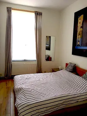 a bedroom with a large bed with a large window at Nest in Brussels in Brussels