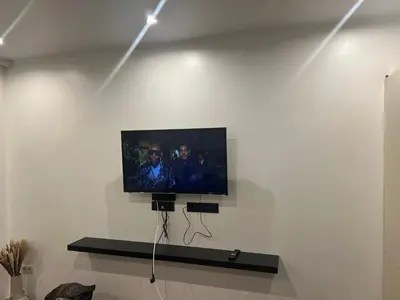 a flat screen tv on a white wall at A soothing nest in Brussels