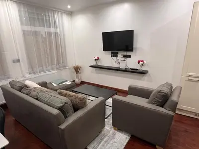 a living room with two couches and a flat screen tv at A soothing nest in Brussels