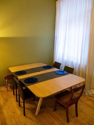 a wooden table with four chairs and a curtain at Spacious home in the heart of Antwerp! in Antwerp
