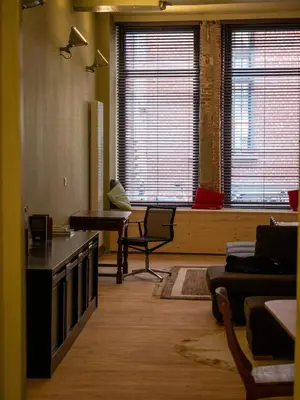 a living room with a couch and a table and windows at Spacious home in the heart of Antwerp! in Antwerp