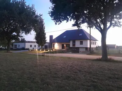 a large white house with a blue roof at Vakantiehuis 't Alkeveld in Zottegem