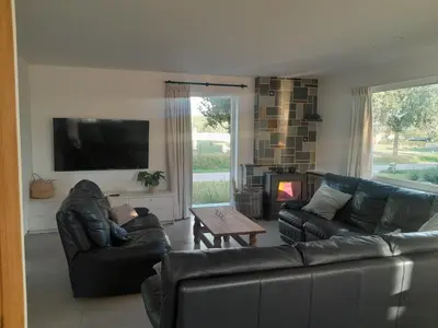 a living room with two leather couches and a television at Vakantiehuis 't Alkeveld in Zottegem