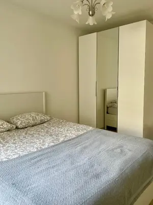 a bedroom with a bed and a chandelier at Bright & Peaceful Appartment in Koningslo in Vilvoorde