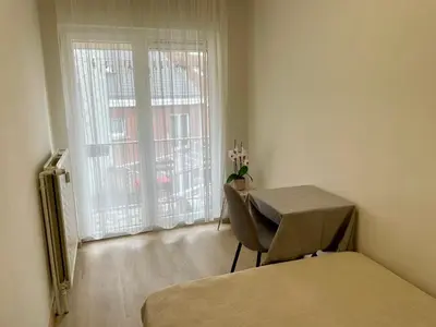 a room with a bed and a table and a window at Bright & Peaceful Appartment in Koningslo in Vilvoorde