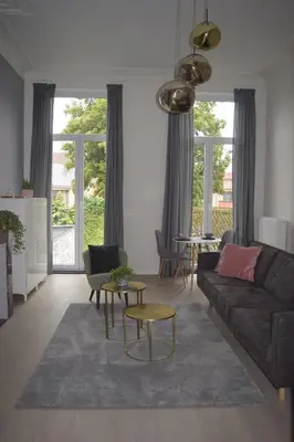 a living room with a couch and a table at Holiday Home La Petite Maison in Ghent