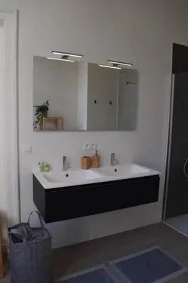 a bathroom with two sinks and a mirror at Holiday Home La Petite Maison in Ghent