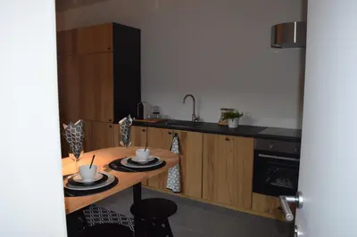 a kitchen with a wooden table with two cups on it at Holiday Home La Petite Maison in Ghent