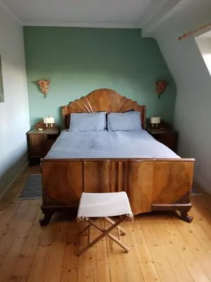a bedroom with a large wooden bed and a chair at Guest House Dasos Kynthos in Brussels