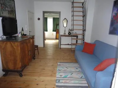 a living room with a blue couch and a television at Guest House Dasos Kynthos in Brussels