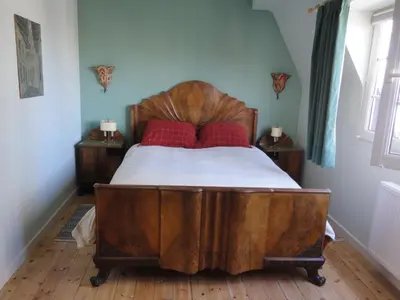 a bedroom with a wooden bed with red pillows at Guest House Dasos Kynthos in Brussels