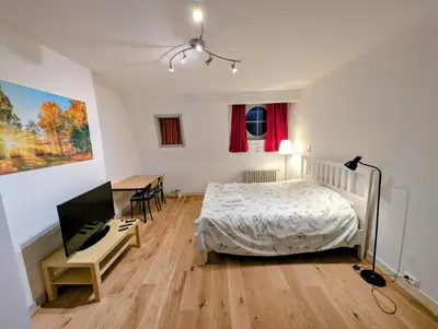 a bedroom with a bed and a desk and a television at Duplex 3BR apartment near supermarkets & metro in Brussels
