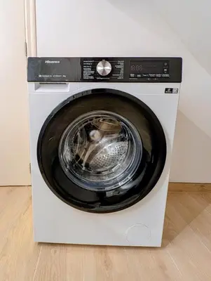 a washing machine is sitting in a room at Duplex 3BR apartment near supermarkets & metro in Brussels