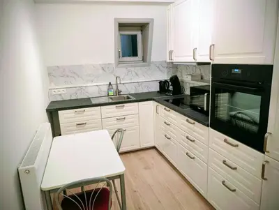 a kitchen with white cabinets and black appliances at Duplex 3BR apartment near supermarkets & metro in Brussels