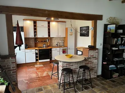 a kitchen with a table and some stools in it at Ground floor in Brussels