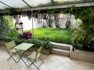 a patio with a table and chairs and a garden at Ground floor in Brussels