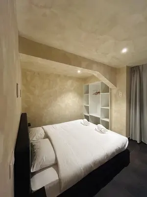 a bedroom with a large bed with white sheets at Fiori private wellness en hotel in Lier