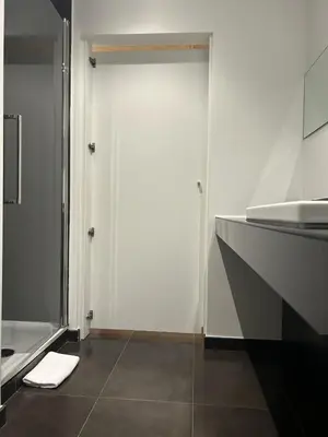 a bathroom with a white door and a sink at Fiori private wellness en hotel in Lier
